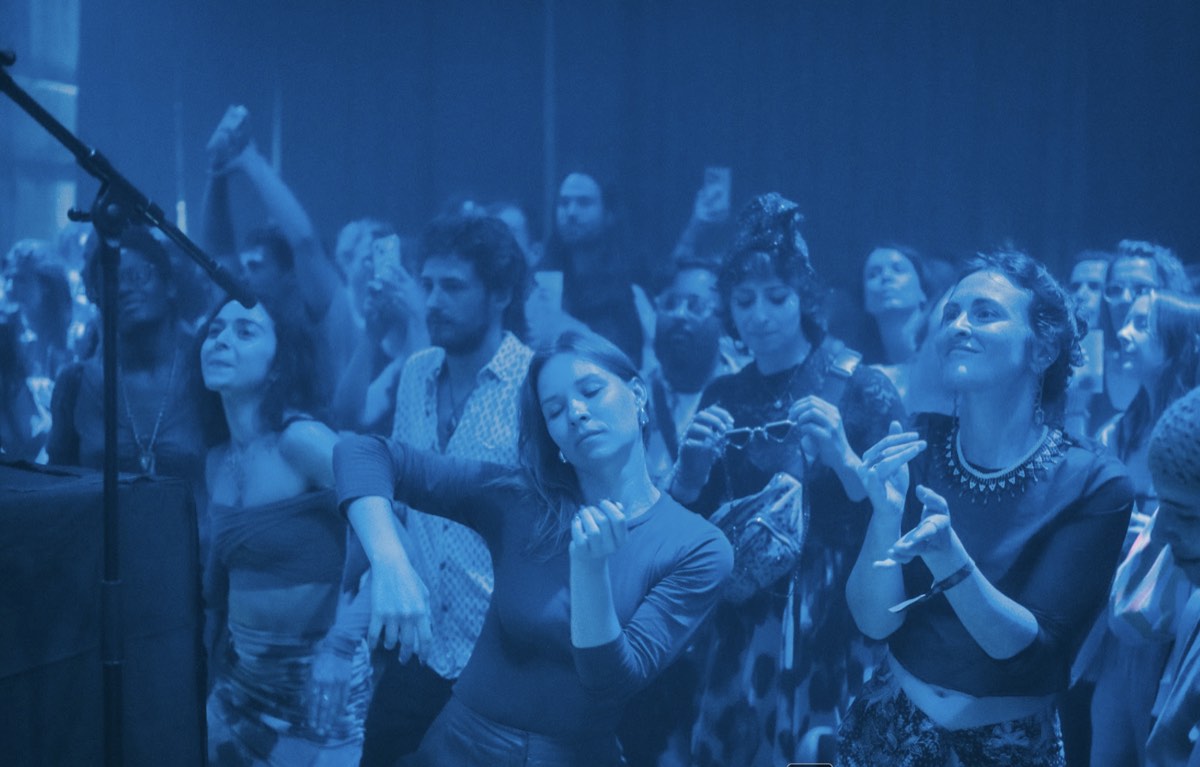 Crowd dancing under blue lights at conscious dance event in Mafra