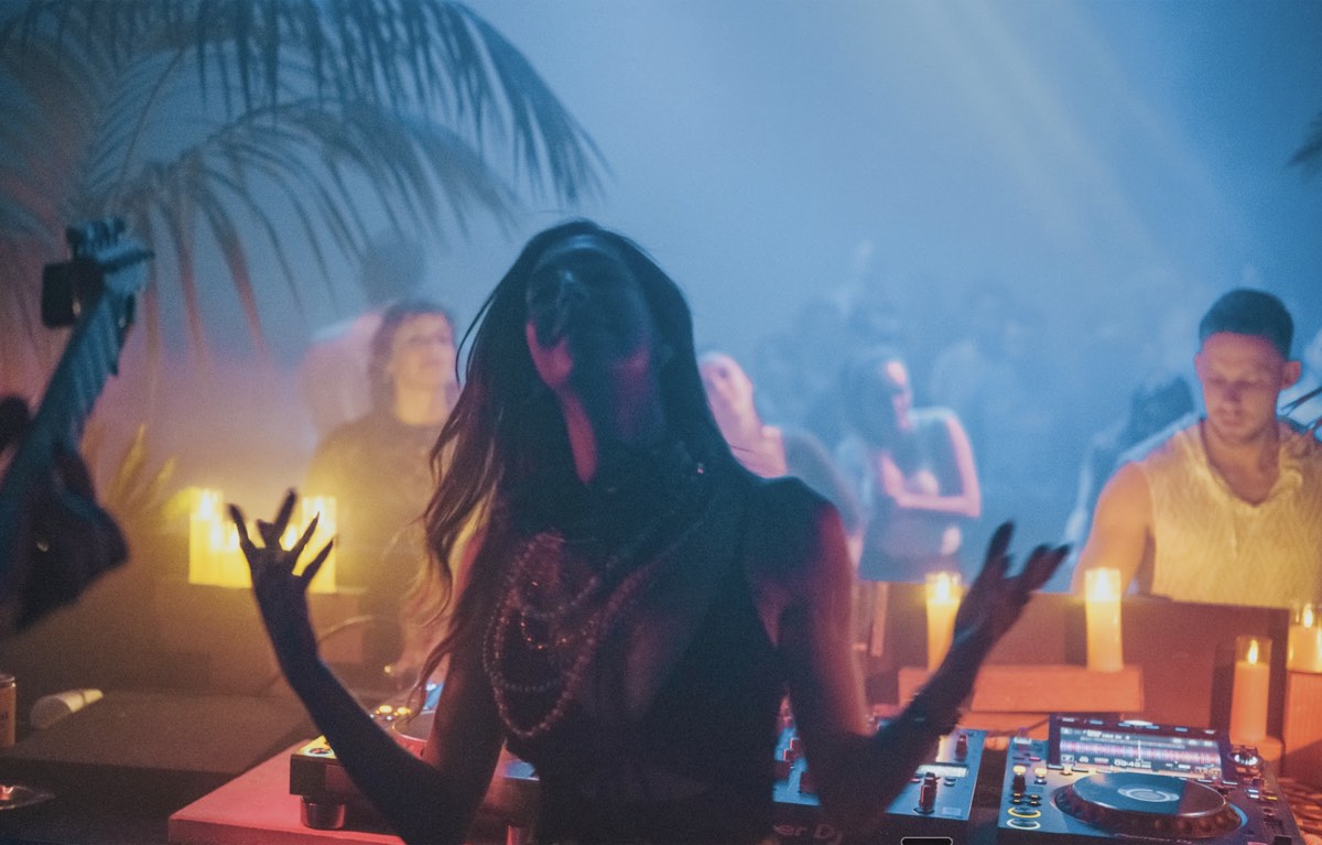 DJ performing live set surrounded by candlelight at EDLX